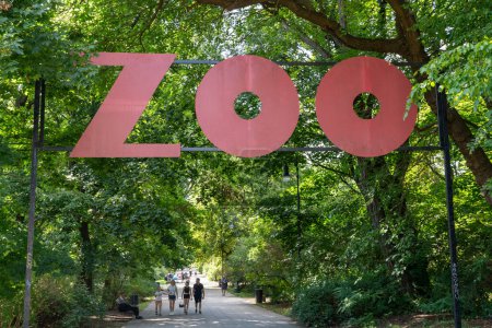 Foto de ZOO polaco. Letrero de palabras. Señal de entrada. Callejón en un parque verde entre los árboles. Varsovia, Polonia - 28 de julio de 2023. - Imagen libre de derechos