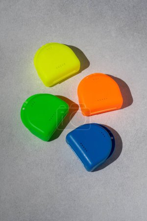 Foto de Envases multicolores para placas dentales. Caja para protector bucal ortodóncico - Imagen libre de derechos