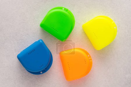 Foto de Envases multicolores para placas dentales. Caja para protector bucal ortodóncico - Imagen libre de derechos