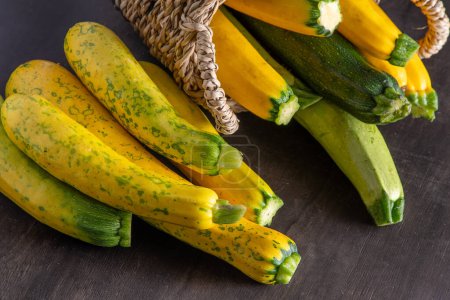 Photo for Yellow green leopard spotted zucchini. Vegetables on the table. vegetable marrow harvest. Food background. Fresh courgette, cropped summer squash. Picked courgettes. Still life in kitchen. - Royalty Free Image