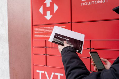 Photo for Receiving mail at the NOVA POSHTA parcel terminal. Contactless sending and delivery of correspondence. Ukraine, Kyiv - March 23, 2024 - Royalty Free Image