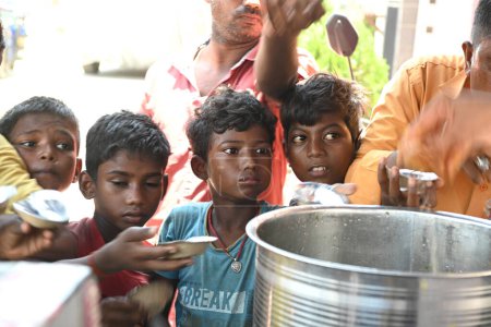 Photo for GAYA, BIHAR, INDIA- July 29 2023 Poor children Kids in queue of free food packet distribution at Bihar, Gaya. - Royalty Free Image