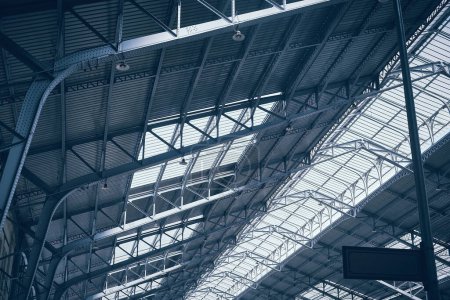 Photo for Metal arched frame construction. Steel roof supporting structures of railway station. Truss supports and glass translucent roof - Royalty Free Image