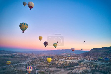 Drone point of view of hot air balloons above spectacular volcanic landscape of Cappadocia. Goreme national park. UNESCO World Heritage site. Nevsehir province, Turkiye