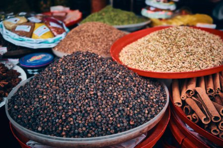 Heaps of peppercorn, cinnamon sticks, sesame and other spices at bazaar market stall