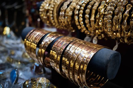 Row of golden jewelry bracelets at traditional middle eastern bazaar