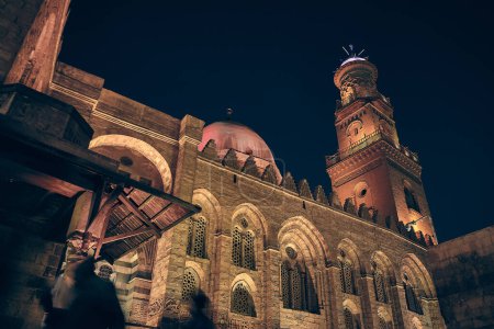 Low angle view of Complex of Sultan al-Mansur Qalawun. Streets of Khan El Khalili bazaar in Cairo, Egypt. Night Cairo street
