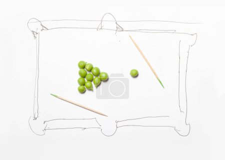Téléchargez les photos : Fun imitation of billiards. A billiard table is drawn on a white sheet. It has a pyramid of green peas. Nearby is a cue ball. There are two toothpicks instead of a cu - en image libre de droit