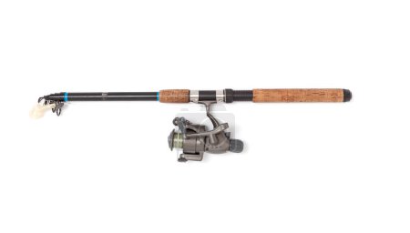 Foto de A folded telescopic spinning rod lies on a white background. A gray inertialess reel is fixed on it with a fishing line and a twiste - Imagen libre de derechos