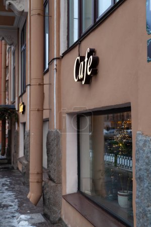 Téléchargez les photos : Soirée rue de la ville avec inscription café au premier étage du bâtiment brun - en image libre de droit