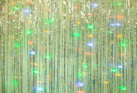 Photo for Photo zone for a Christmas party. Background for photography from green tinsel and blurry lights of a luminous garland at a long exposur - Royalty Free Image