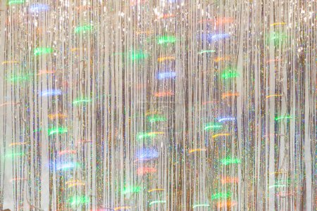 Photo for Photo zone for a Christmas party. Background for photography from silver tinsel and blurry lights of a luminous garland at a long exposur - Royalty Free Image