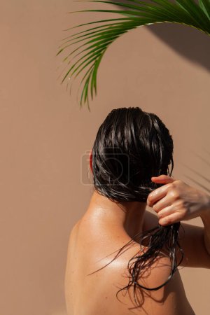 Photo for Portrait of a girl under a palm tree. Above a beautiful girl, the graceful curve of a green areca palm tree branc - Royalty Free Image