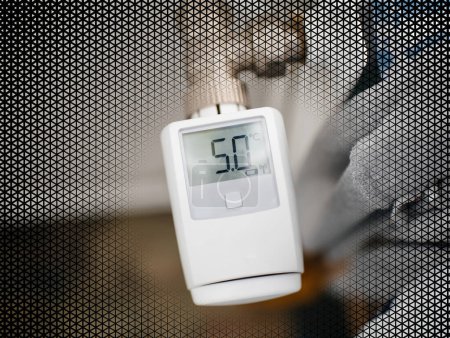 Téléchargez les photos : Gros plan du thermostat électronique intelligent à réglage automatique de la température via l'application tablette smartphone - 5 degrés Celsius sur écran numérique, faible signal de batterie - effet mosaïque autour - en image libre de droit