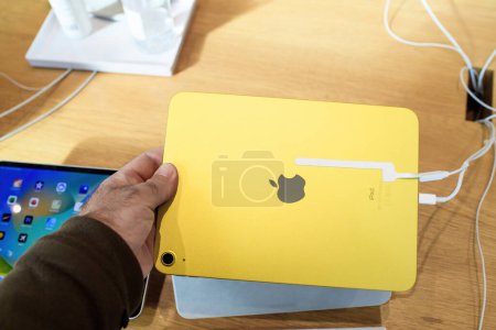 Foto de París, Francia - 28 de octubre de 2022: Hombre usando el nuevo Apple Computers iPad 10ª generación en color amarillo en la tienda - mirando a la cámara trasera - Imagen libre de derechos