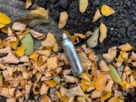Téléchargez les photos : Récipients usagés d'oxyde nitreux jetés trouvés sur le sol de la ville - connus sous le nom de NOS ou gaz hilarant - utilisés par les jeunes comme drogue - en image libre de droit