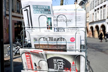 Photo for Paris, France - Mar 20, 2015: Tilt-shift lens International French press for sale at press kiosk in central Paris with buildings in background - business, current affairs and politics coverage - Royalty Free Image