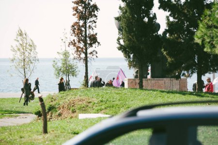 Téléchargez les photos : Thessaloniki, Greece - Oct 30, 2014: People with flags protesting in in front of National Resistance Monument located in 30th of October Park with Aegean sea in background - en image libre de droit