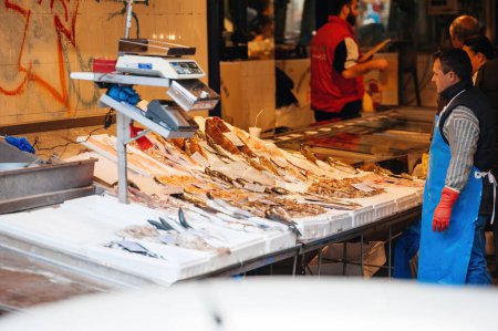 Téléchargez les photos : THessaloniki, Grèce - 30 octobre 2014 : Vendeur pêcheur au marché central du poisson dans le centre de Thessalonique - en regardant les diverses espèces de poissons prêts à rencontrer les clients - en image libre de droit