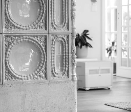 Téléchargez les photos : Intérieur moderne avec carreaux de céramique de luxe d'un poêle alsacien en maçonnerie Kachelofen avec purificateur d'air en arrière-plan image noir et blanc - en image libre de droit