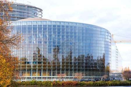 Photo for Strasbourg, France - Nov 22, 2022: Cars parked near European Parliament facade during 70 years of European democracy in action large banner on facade during ceremony marking the 70th anniversary - Royalty Free Image