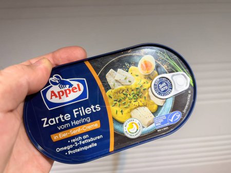 Photo for Frankfurt, Germany - Oct 8, 2022: POV male hand holding fish preserve can with Appel Zarte filets from Hering with eier senf egg mustard creme - Royalty Free Image