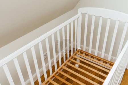 Téléchargez les photos : Vue d'en haut du nouveau lit d'enfant sans matelas dans la chambre d'enfant - concept de préparation à l'arrivée du bébé de déménagement - en image libre de droit
