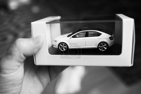 Photo for London, United Kingdom - Oct 25, 2022: Black and white POV Male hand holding new Skoda Vision presentation for scale car model - Royalty Free Image