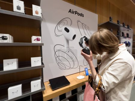Foto de París, Francia - Spe 9, 2022: Mujer teste lage nuevos auriculares EarPods Max dentro de Apple Store - Imagen libre de derechos