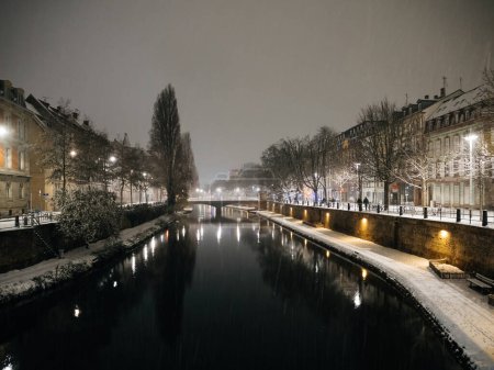 Téléchargez les photos : Vue aérienne de l'hiver Strasbourg à l'aube du soir, parc naturel enneigé, rivière Ill et quartiers résidentiels en arrière-plan, avec des conditions météorologiques pittoresques - en image libre de droit