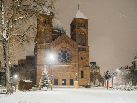 Foto de Iglesia católica Eglise Saint-Pierre-le-Jeune de Strasbourg por la noche durante una tormenta de nieve - turismo Alsacia, Estrasburgo Francia - Imagen libre de derechos
