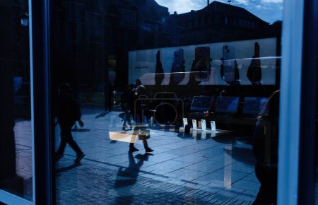 Téléchargez les photos : Strasbourg, France - 28 oct. 2022 : Intérieur de l'Apple Store avec rangée de nouveaux Apple iPhone 14 pro avec reflets de piétons dans la vitrine en verre - coulée de couleur bleue - en image libre de droit