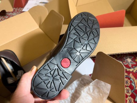 Téléchargez les photos : London, October 20, 2022: Personal perspective looking at the Logotype of the sole of new brand modern Camper leather shoes - manufactured by footwear company with headquarters in Mallorca, Spain - en image libre de droit
