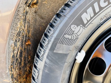 Photo for Clermont-Ferrand, France - Oct 17, 2022: Close-up of new Michelin Alpin 6 Premium touring winter tyre mounted on a new rhim wheel - Michelin man waving hand - Royalty Free Image