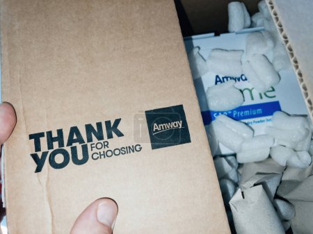 Foto de Paris, France - Sep 12, 2022: Thank you for choosing Amway text on the cardboard package during unboxing unpacking of detergents home products - Imagen libre de derechos