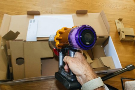 Photo for Paris, France - Jul 4, 2022: Man hand holding during unboxing new modern wireless Dyson V12 Detect Slim Absolute Vacuum Cleaner powerful cordless colorful cyclonic dust collection - Royalty Free Image