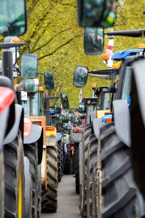 Téléchargez les photos : Strasbourg, France - April 30, 2021: Perspective view through rows of tractors roll for farmer protest in Strasbourg to put pressure on CAP negotiations underway in Brussels - en image libre de droit