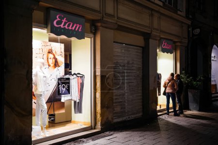 Foto de Strasbourg, France - Sep 18, 2015: Etam French lingerie store at night with couple looking at the showcase - Imagen libre de derechos