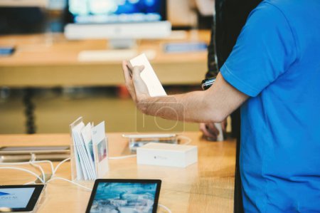Foto de Strasbourg, France - Sep 19, 2014: Genius worker in blue t-shirt scanning barcode of recently sold iPhone Smartphone by Apple Computers during sale launch - Imagen libre de derechos