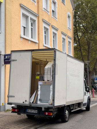 Photo for Frankfurt, Germany - Sept 24, 2022: White transportation van with washing machine inside delivery to a new client of household appliance - Royalty Free Image