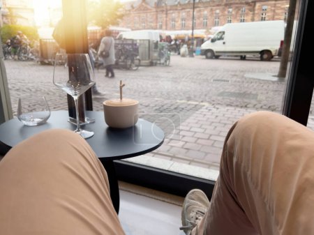 Téléchargez les photos : Man sitting in luxury chair admiring from cafe window the calm skuare of Place Kleber in Strasbourg with pedestrians and cars vans at daily market - SUNLIGHT FLARE RIGHT CORNER - en image libre de droit