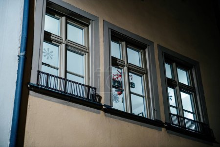 Téléchargez les photos : View from the street low angle view of an apartment building with Christmas decorations near the windows and hanged to the ceiling - en image libre de droit