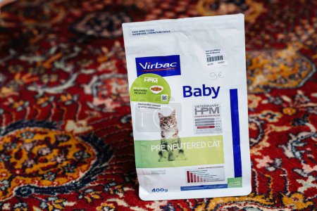 Photo for Paris, France - Dec 16, 2022: Open package with Virbac Baby Pre Neutered Cat dry pet food on the silk rug in living room - elevated view - Royalty Free Image