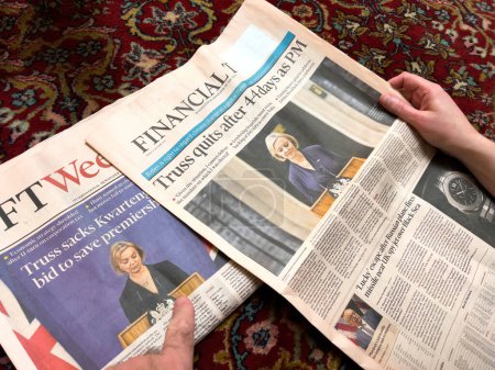Téléchargez les photos : London, United Kingdom - Feb 2, 2022: Woman hand reading Financial Times newspaper with cover - Truss quits after 44 days as PM - en image libre de droit