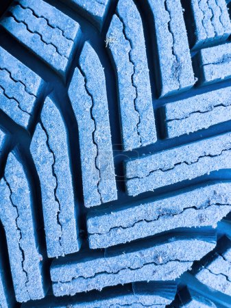 Photo for Close-up macro shot of a winter tire covered with dust - brand new wheels for the upcoming cold season - mandatory protection during cold weather - blue color cast - Royalty Free Image