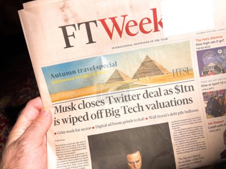 Téléchargez les photos : Paris, France - Oct 29, 2022: REader hand holding Financial Times newspaper with headline Elon Musk closes twitter deal as 1 trillion is wiped off big tech valuations - en image libre de droit