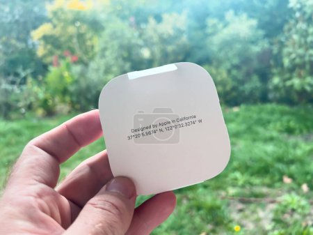 Foto de Paris, France - Oct 18, 2022: Designed by Apple in California with GPS coordinates of Cupertino on new packaged Apple Watch Magnetic Fast Charger to USB-C cable - nature garden background - Imagen libre de derechos