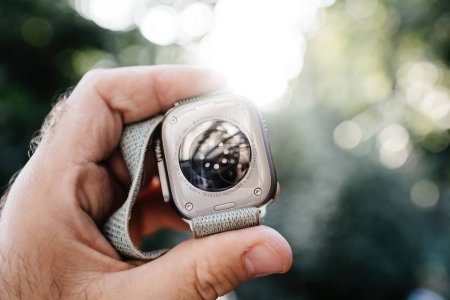 Photo for London, United Kingdom - Sept 28, 2022: Male hand holding new Apple Watch Ultra Smartwatch against defocused bokeh background with multiple sensors on the titanium ceramic case saphyre chrystall glass - Royalty Free Image