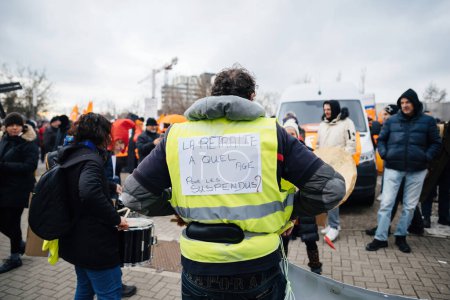 Téléchargez les photos : Strasbourg, France - Jan 19, 2023: Man with message to authorities on his yellow vest protest against the French governments planned pension reform to push the retirement age from 62 to 64 unions - en image libre de droit