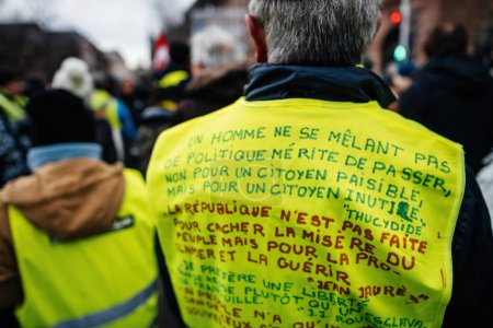 Photo for Strasbourg, France - Jan 19, 2023: Long message by Thucydides on yellow vest at protest against the French governments planned pension reform to push the retirement age from 62 to 64 unions have - Royalty Free Image